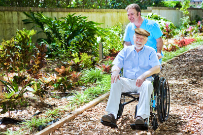 caregiver assisting a senior man on a wheelchair